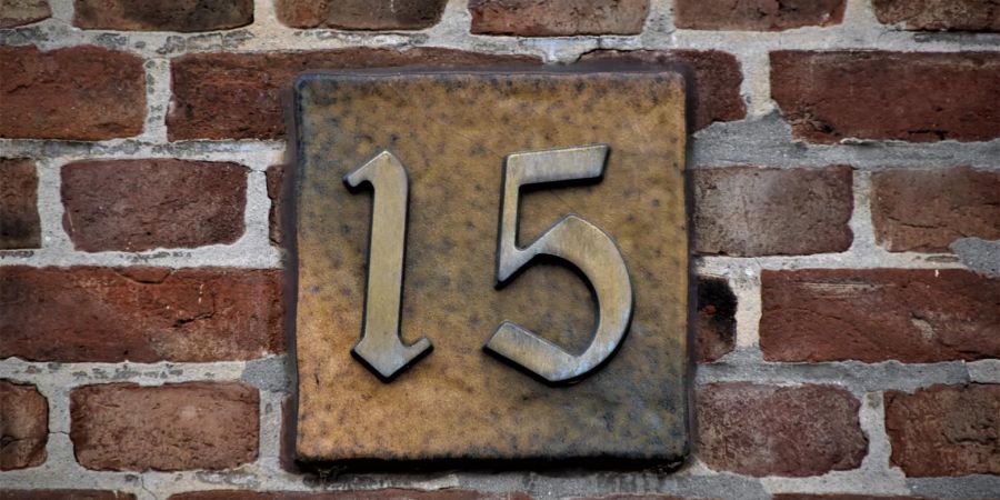 number 15 on a brick wall