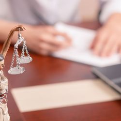 someone at a desk with a justice statue folding an envelope